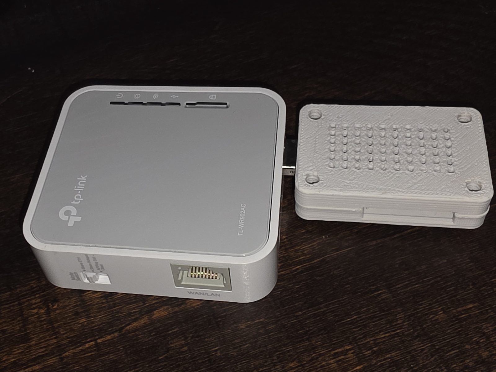The DIY 4G link: a Quectel EC25-A modem in a 3D-printed enclosure, beside the TP-Link TL-WR902AC travel router it hands Wi-Fi to.